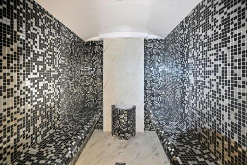 a bathroom with black and white tiles on the wall at Difc 1 Bd apartment in Park Tower in Dubai