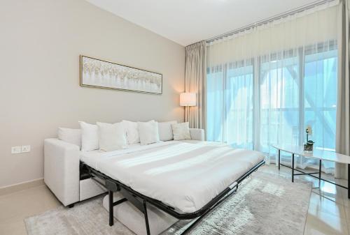 a white bedroom with a large bed and a window at Difc 1 Bd apartment in Park Tower in Dubai