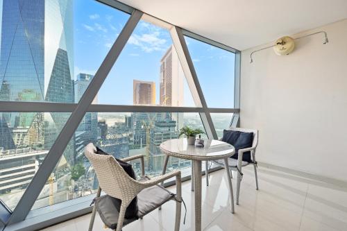 a table and chairs in a room with large windows at Difc 1 Bd apartment in Park Tower in Dubai