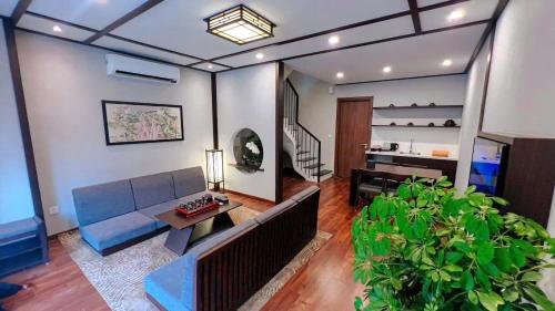 a living room with a blue couch and a table at Wyndham Lynn Times Thanh Thủy Onsen Sweet Home in La Phu