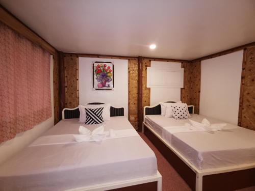 een kamer met twee bedden in een kamer bij Kimura Beachfront Villas El Nido in El Nido