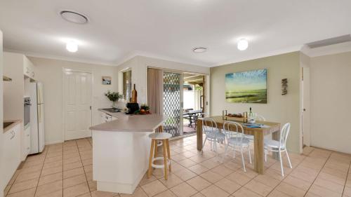 a kitchen and dining room with a table and chairs at The Coastal Corner in Culburra Beach