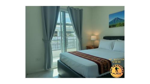 ein Hotelzimmer mit einem Bett und einem Fenster in der Unterkunft One Travelers Place in Koronadal