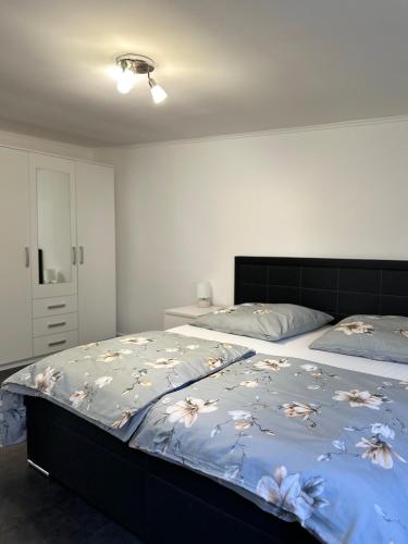 una camera da letto con un letto con un piumone blu decorato con fiori sopra di Ferienwohnung - An der Oder a Barbis