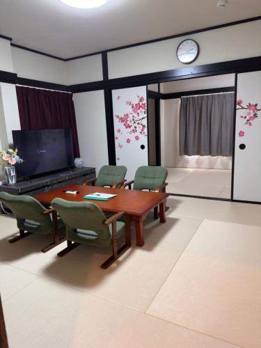 a dining room with a table and chairs and a clock at 阿久津ハイツ201 in Tokyo