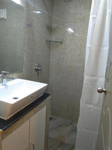 a bathroom with a sink and a shower at Chandru De Green in Chennai