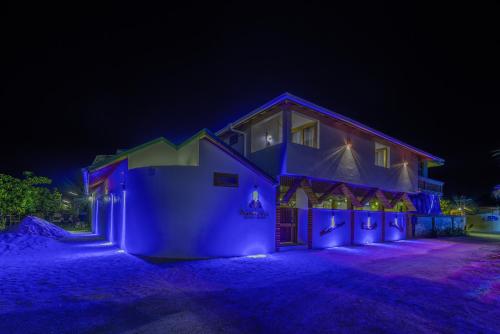 una casa illuminata di notte in blu di Ameera Maldives a Dhiffushi