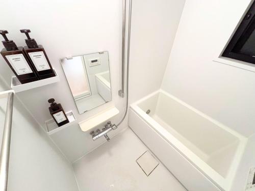 a white bathroom with a sink and a mirror at FARE Akihabara - Stylish Spacious Studio 8min from Station 201 in Tokyo