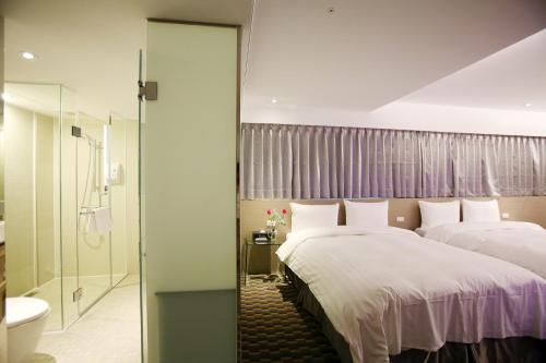 a hotel room with two beds and a shower at Chiayi Look Hotel in Chiayi City
