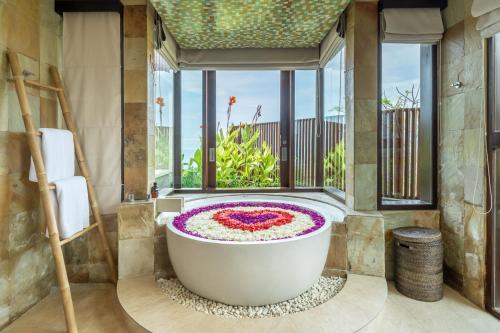 Forever Bali Villas في أُلُواتو: حوض استحمام في حمام به نافذة كبيرة