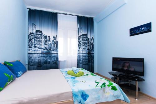 a bedroom with a bed and a tv in a room at Apartlux Krasnopresnenskaya in Moscow