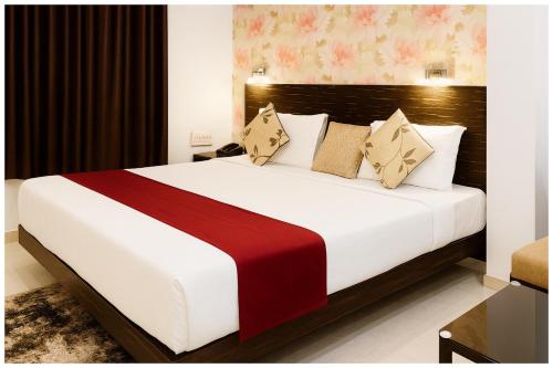 a bedroom with a large bed with a red and white blanket at Kanha Classic Inn Near Lucknow Railway Station # Free Wifi # Room Service And Parking Facility - Fully Air conditioning Premium Room - Best Premium Hotel In Lucknow in Lucknow