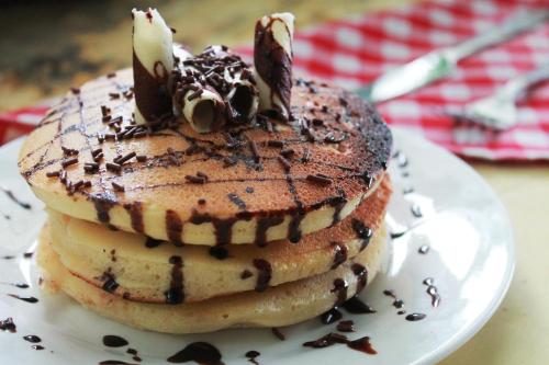 a stack of pancakes on a plate on a table at Austria's Guest House in El Nido