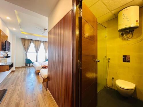 Pine Rock Hotel in Mussoorie Peaceful Stay في موسوري: حمام مع مرحاض ومغسلة في الغرفة