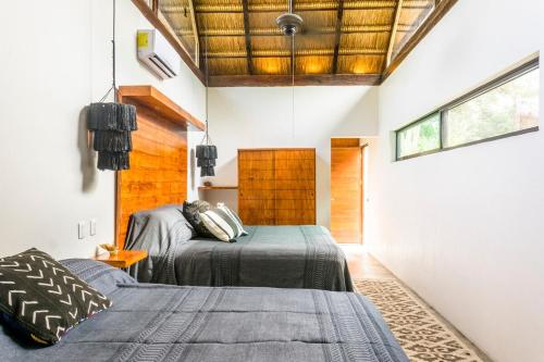 a bedroom with two beds and a wooden ceiling at Tulum Private Villa, Weddings, Retreats, Groups in Tulum