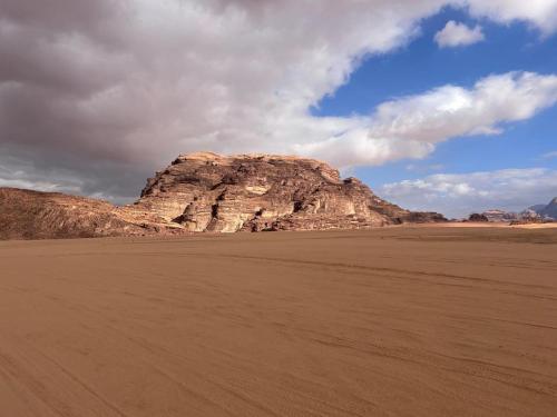 a large rock in the middle of a desert at Bedouin Luxe Camp & Tour in Wadi Rum
