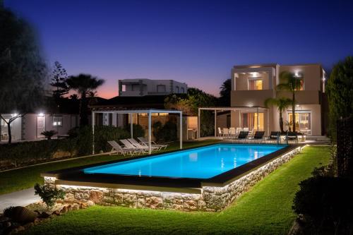 a villa with a swimming pool at night at Sea Homes Villas-Villa Sylvia in Kiotari