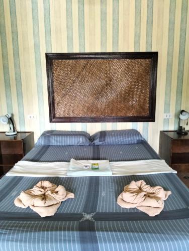 a bed with two towels on top of it at Eddie`s Beach Resort Siargao in General Luna