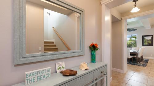 ❤PiH❤ Seashell Villa Bikes Free Resort Passes Free Private Beach Club في وايكولوا: مرآة على جدار فوق خزانة في الغرفة