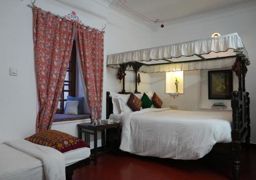 una camera da letto con due letti e una sedia di Little Garden Guest House a Udaipur