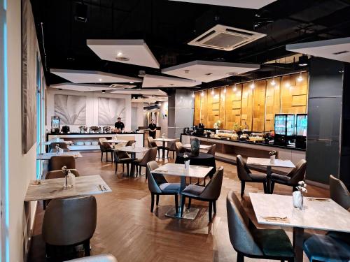 um restaurante com mesas e cadeiras e um balcão em Cormar Residences Kuala Lumpur em Kuala Lumpur
