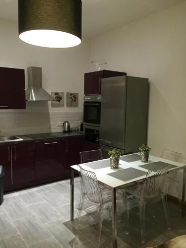 une cuisine avec une table avec des chaises et un réfrigérateur dans l'établissement CANNES CROISETTE b, à Cannes