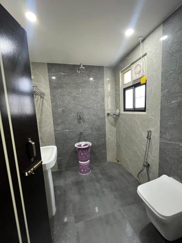 a bathroom with a toilet and a sink at ClubGreens in Jorhat
