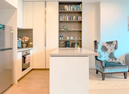 a kitchen with a counter and a blue chair at Aspire Boutique Condo Melbourne CBD in Melbourne