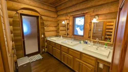 a bathroom with two sinks in a log cabin at Hakuba Loghouse in Hakuba
