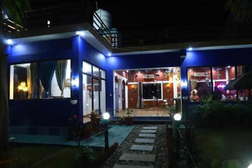 una casa con luci blu di notte di The Tiger Waterfront Resort a Mādho Tānda