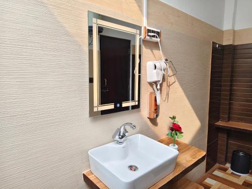 The Tiger Waterfront Resort في Mādho Tānda: حمام مزود بحوض ومِرآة