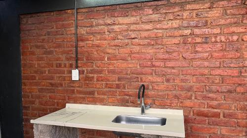 een gootsteen voor een bakstenen muur bij Alojamiento Los Nonos in Las Compuertas