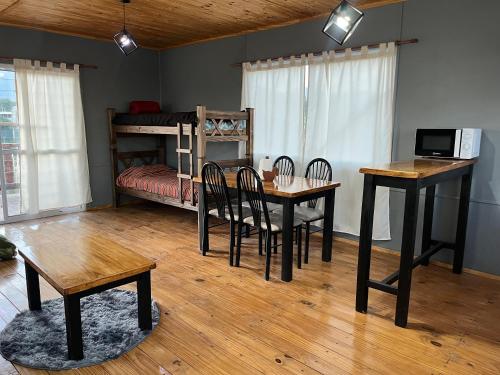 een kamer met een tafel en stoelen en een stapelbed bij Alojamiento Los Nonos in Las Compuertas