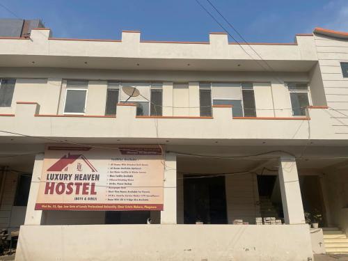 a building with a hotel sign in front of it at Luxury Heaven Hostel for students, parents and guests in Chaheru