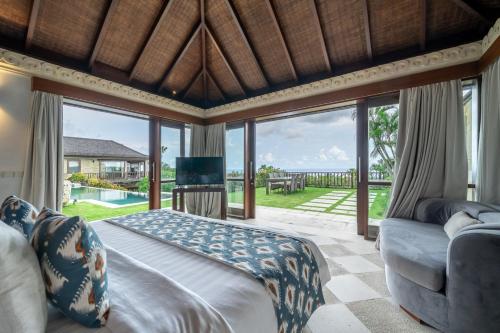 Forever Bali Villas في أُلُواتو: غرفة نوم مع سرير وإطلالة على المحيط