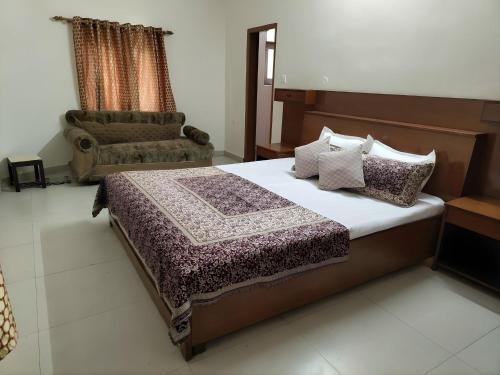 a bedroom with a bed and a couch and a chair at HillNesst -Private 3-Bedroom Mountain Home in Bhowali in Bhowāli