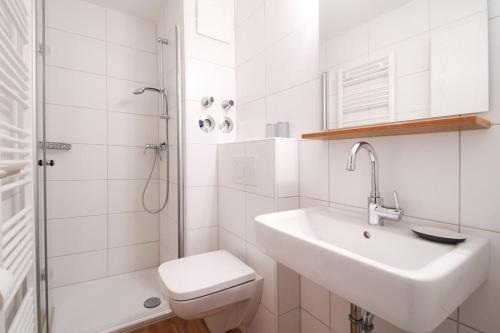 a white bathroom with a sink and a toilet at Fewo Jule in Norderney