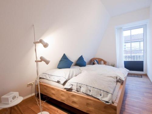 a bedroom with a bed with blue pillows at Fewo Jule in Norderney