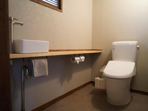 a bathroom with a white toilet and a sink at Newopen 一棟貸切宿YUNOWA 車3台駐車可 6名様まで同料金 in Nagato
