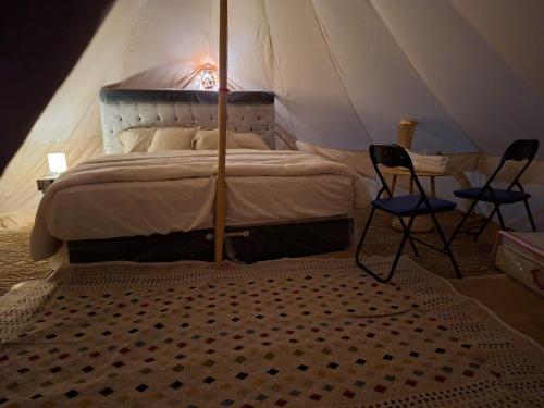 1 dormitorio con cama con dosel, 2 sillas y mesa en ESCAPE cAMp, en Badīyah