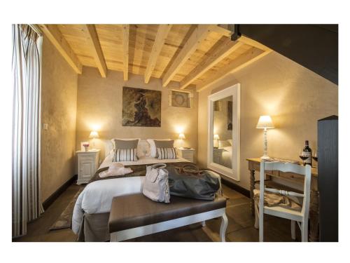a bedroom with a bed and a table and a mirror at La Sauternaise, luxury Boutique B&B in Sauternes