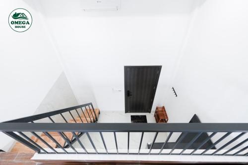 Zimmer mit einer Treppe und einer schwarzen Tür in der Unterkunft OMEGA HOUSE Thốt Nốt in Thốt Nốt