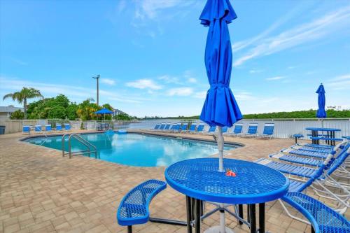 a table with an umbrella next to a swimming pool at Sunset Suite - Private Balcony Gym & Pool in Ruskin