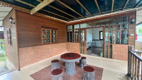 a house with a fireplace in the middle of a room at บ้านกูรูรีสอร์ท in Ban Thung Satong