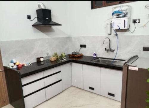 a kitchen with white cabinets and a sink at Madhav Villa in Jaipur