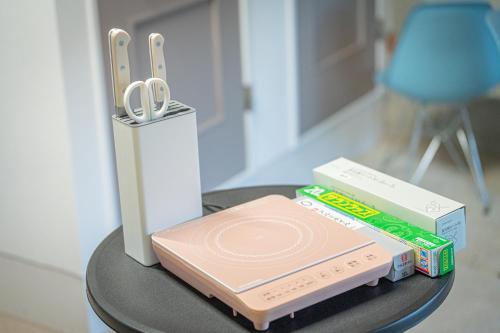 a table with a wii remote and a box and scissors at HANABI棟 8人宿泊 サウナあり ペット不可 - Base棟 4人宿泊 サウナなし ペット可 - 貸切で最大12名宿泊OK in Katori