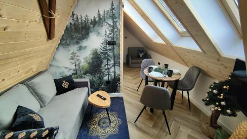 a living room with a couch and a table at Studio Góralskie Klimaty z widokiem na Góry, Kominek, Parking, Jacuzzi, Sauna in Biały Dunajec