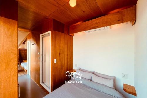 a bedroom with a bed with a wooden ceiling at OceansideRanch Miyazaki in Miyazaki