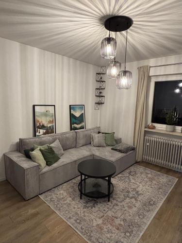 a living room with a couch and a table at Alpenblick - Zentralgelegene 2-Zimmer-Wohnung in Kiefersfelden