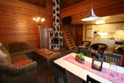 ein Wohnzimmer und eine Küche mit Sofa und Tisch in der Unterkunft Holiday Home Marja-aapa in Luosto